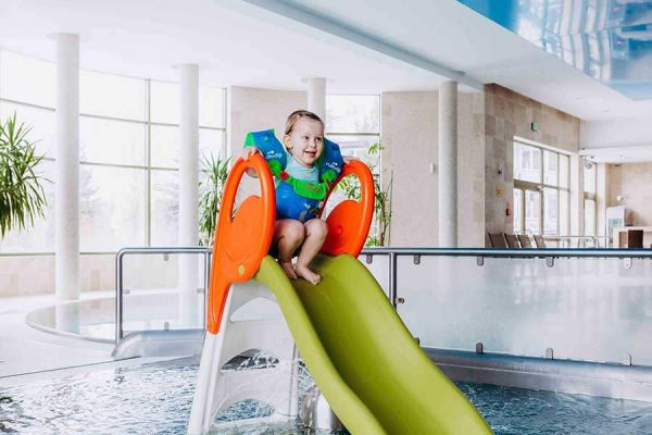 Dziewczynka na zjeżdżalni w basenie w Hotelu Białowieski w Białowieży
